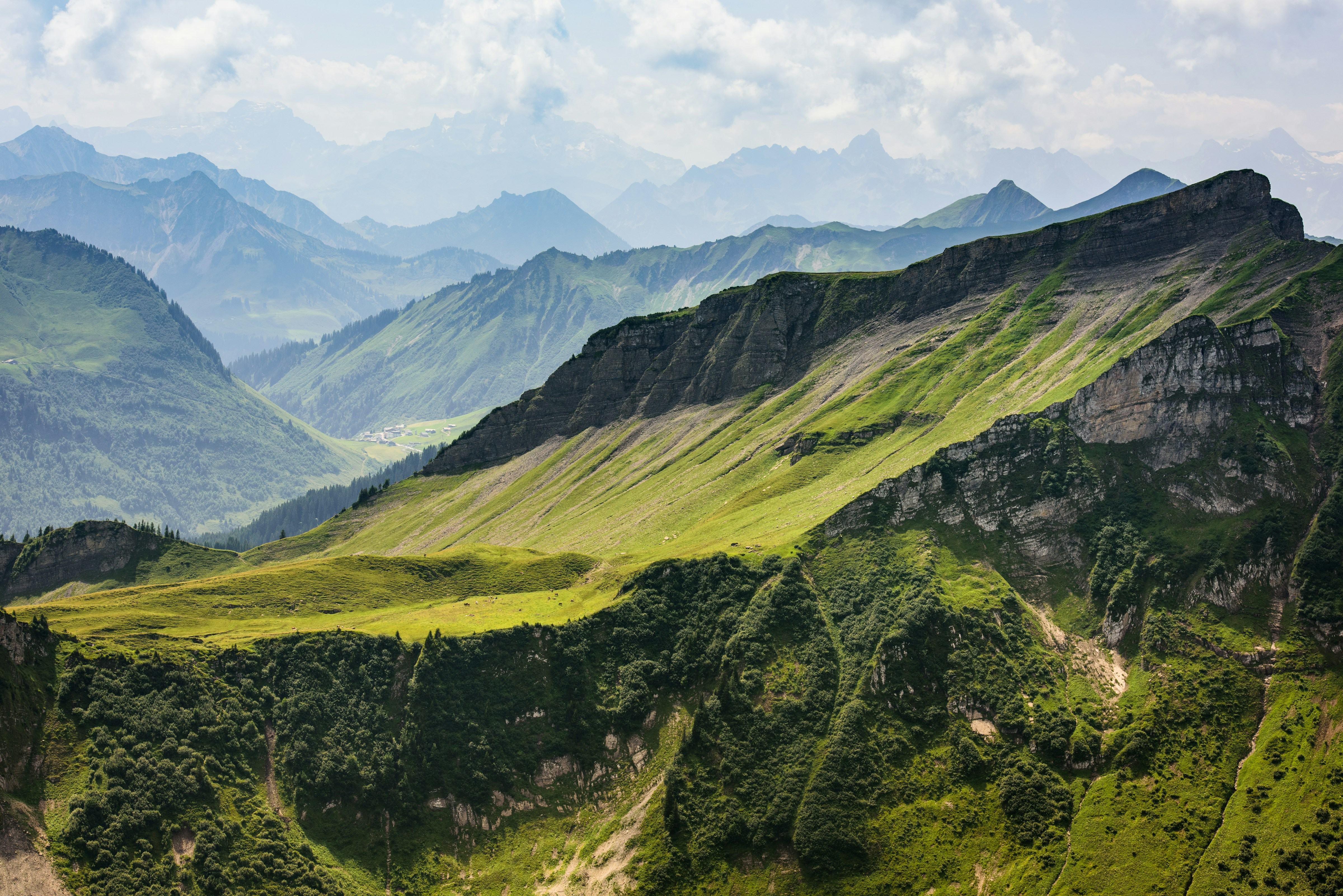 Lush green mountain landscape with rolling hills and cloudy sky